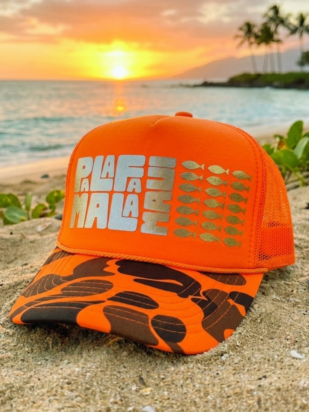 Orange cap with 'PALAFAMALA' text on a beach at sunset