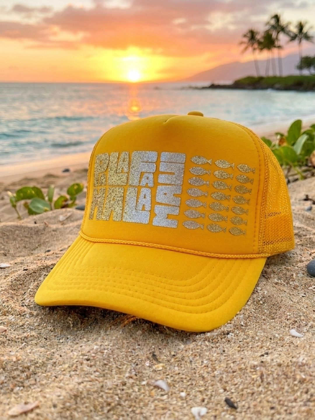 Yellow cap with text on a beach at sunset