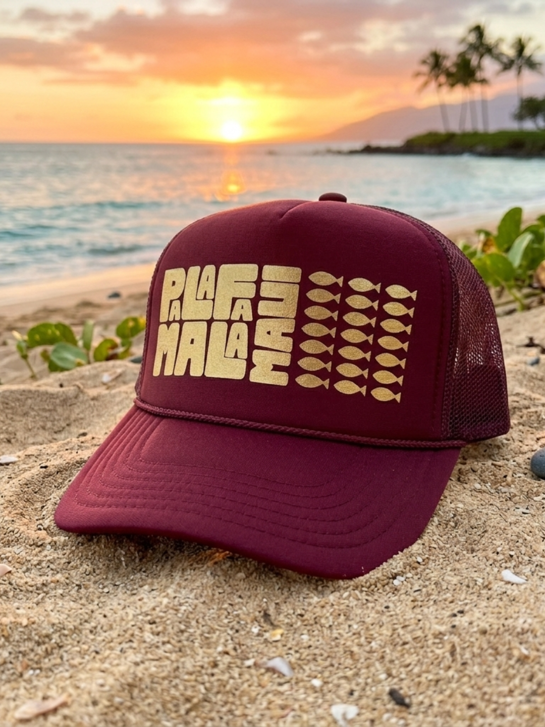 Maroon cap with 'PALAFAMALA' text on a beach at sunset